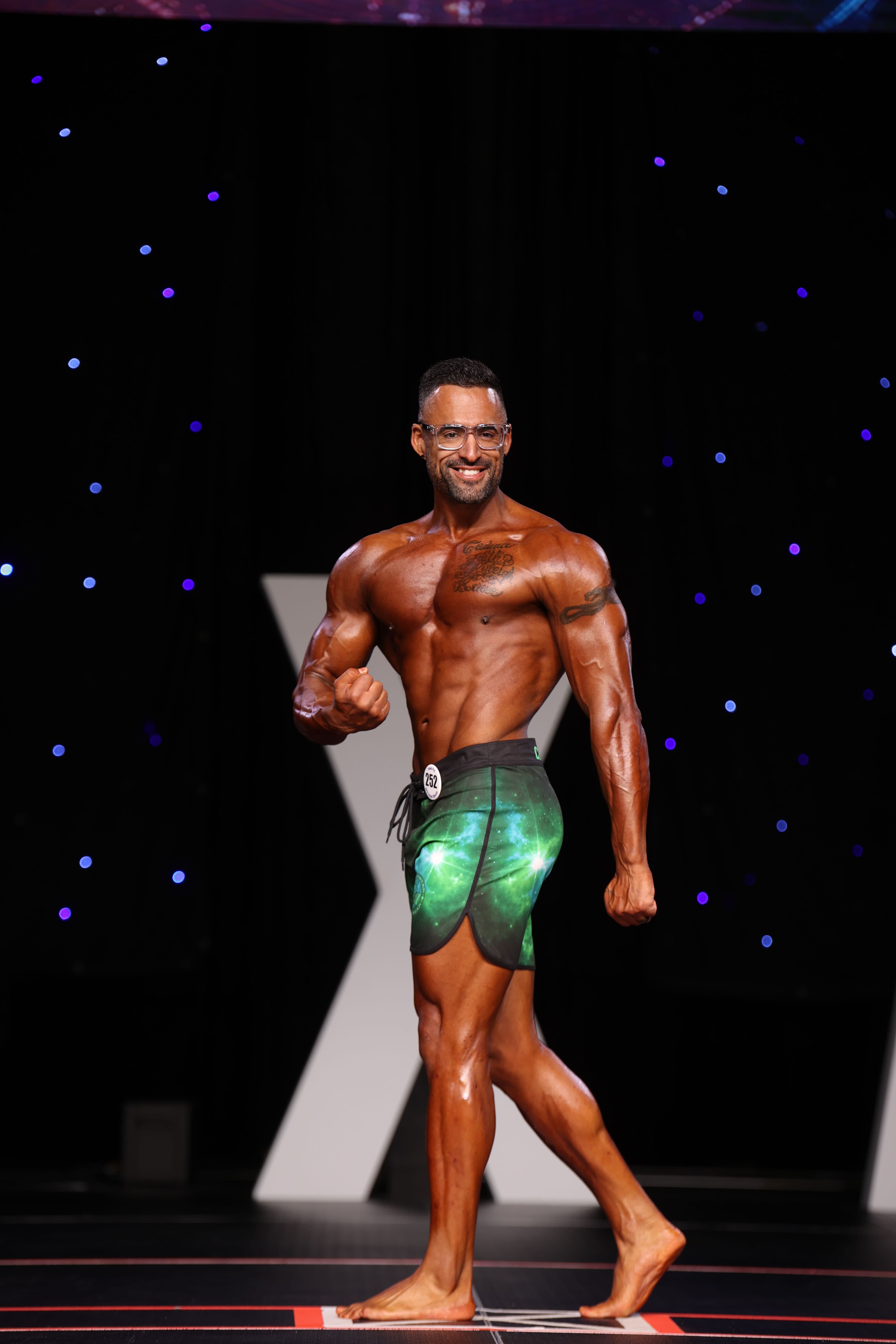 Brent Billue on stage in green galaxy shorts, bib 252
